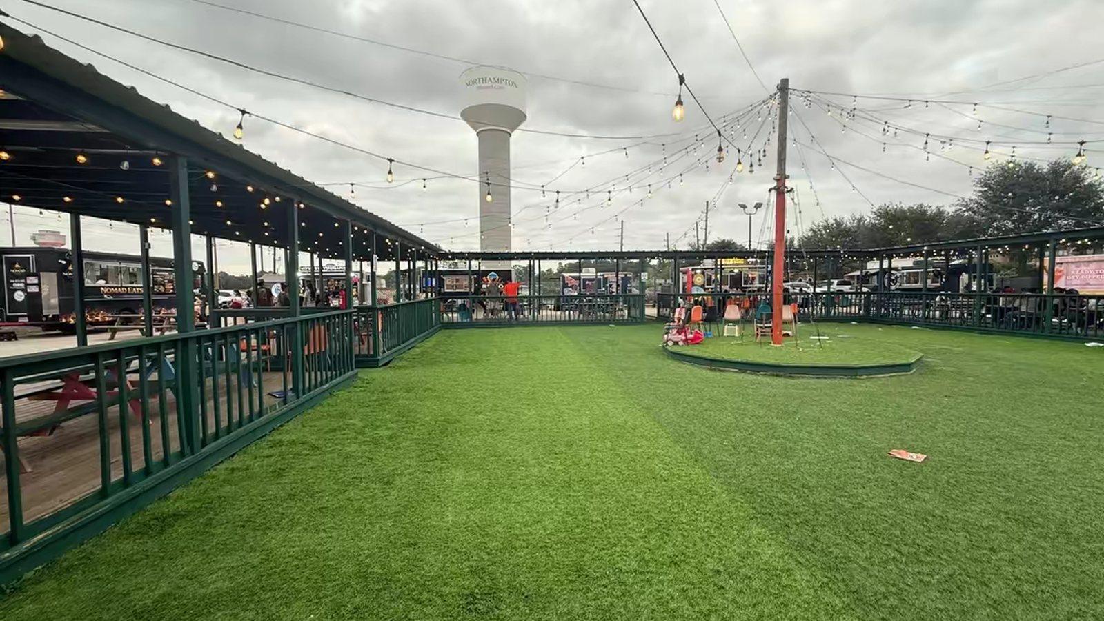 The food truck park at dusk, with the water tower behind the covered seating